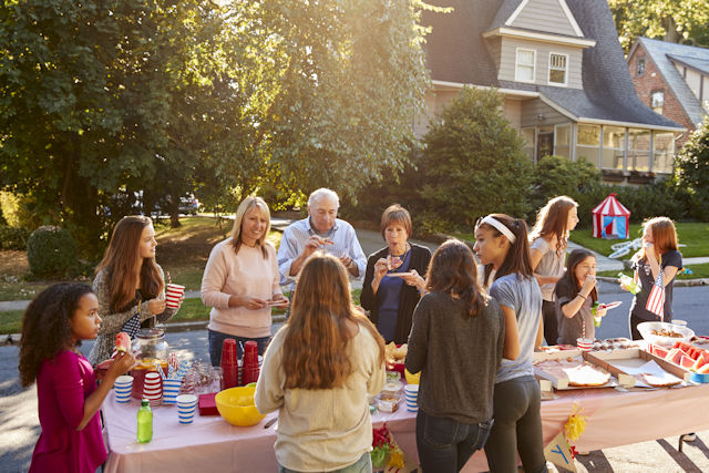 Peoople gathering in a residential neighborhood to celebrate and have a picnic.